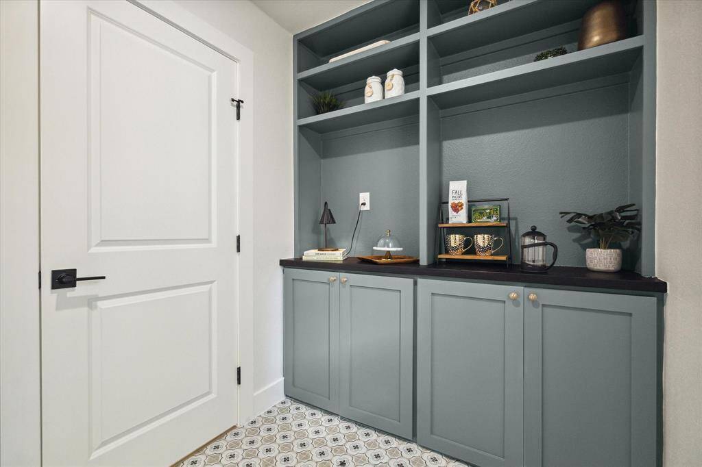 CUSTOM BUILT IN PANTRY WITH AMPLE CABINET SPACE AND GRANITE COUNTERTOP.
