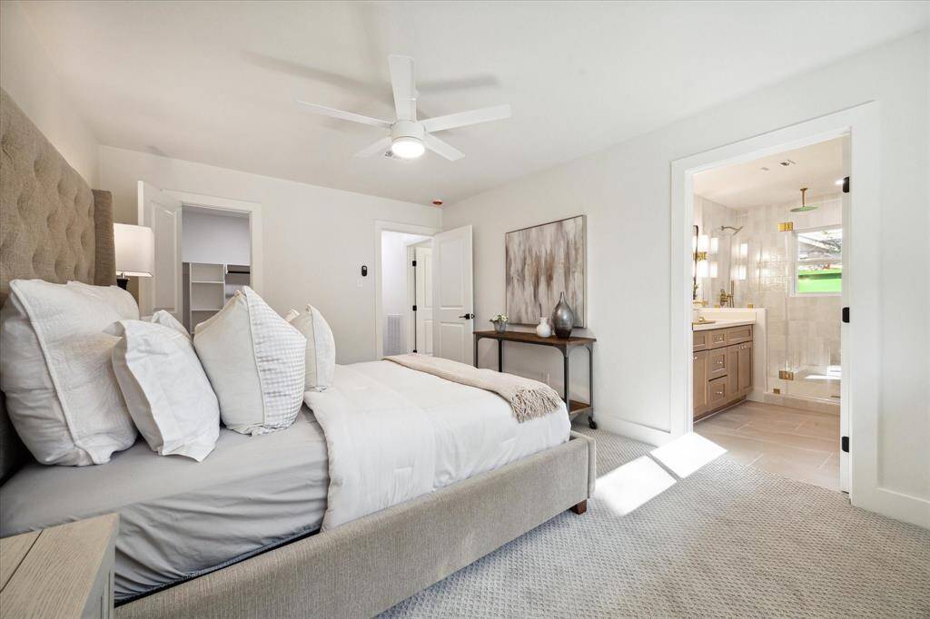 DOUBLE DOORS IN THE PRIMARY SUITE OPEN UP TO THE LUXURIOUS DESIGNER EN-SUITE BATHROOM.