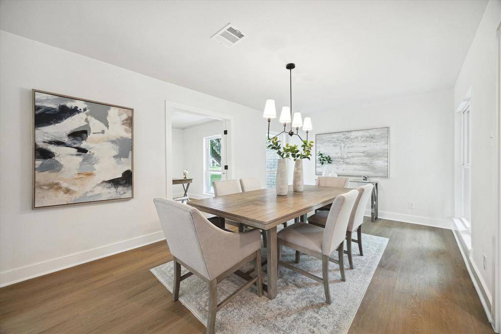 THE FORMAL DINING AREA FEATURES STYLISH CHANDELIER WITH LARGE WINDOWS MAKING IT BRIGHT AND AIRY.