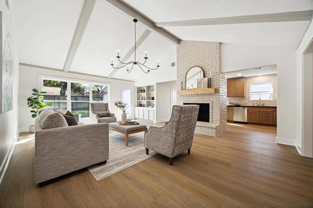 THE FAMILY ROOM IS BOTH COMFORTABLE AND STYLISH FEATURING SOARING VAULTED CEILING WITH MAGNIFICENT BEAMS. THE IMPOSING FIREPLACE IS A FOCAL POINT ADDING WARMTH AND CHARM.