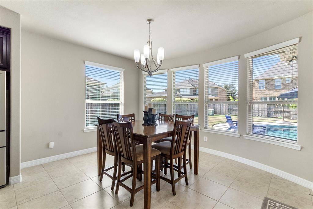 This thoughtfully designed homeseamlessly connects the kitchen witha charming breakfast area featuring tile floors, chandelier, and large windows overlooking the backyard.