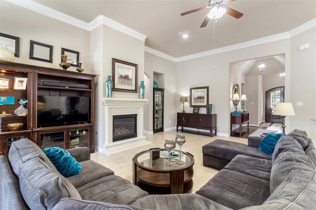 The living room features tile floors, high ceilings, ceiling fan, recessed lighting, and crown molding.