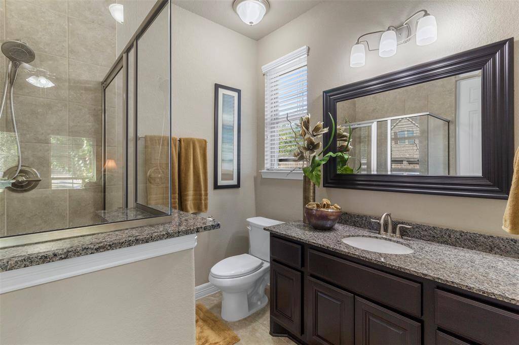 The primary bathroom also has a walk-in shower with tile surround and glass door.