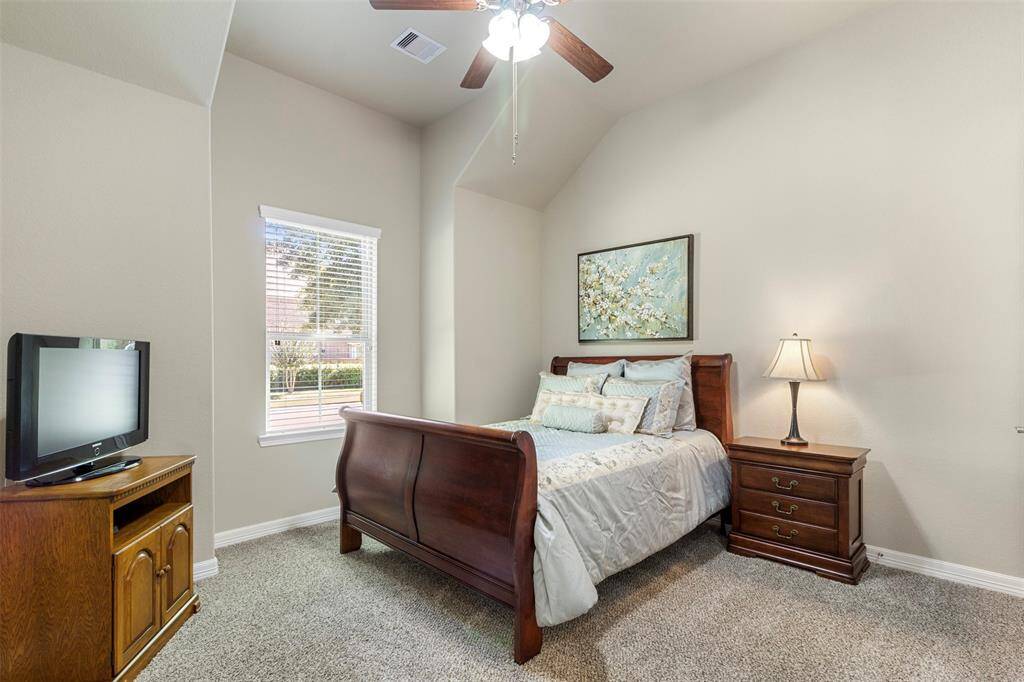 Secondary bedroom features awindow, plush carpet, high ceiling, and ceiling fan.