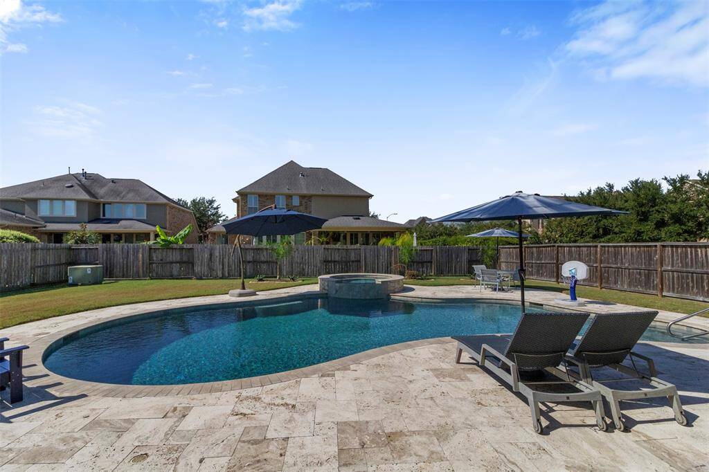 The paved walkway surrounds the pool and spa.