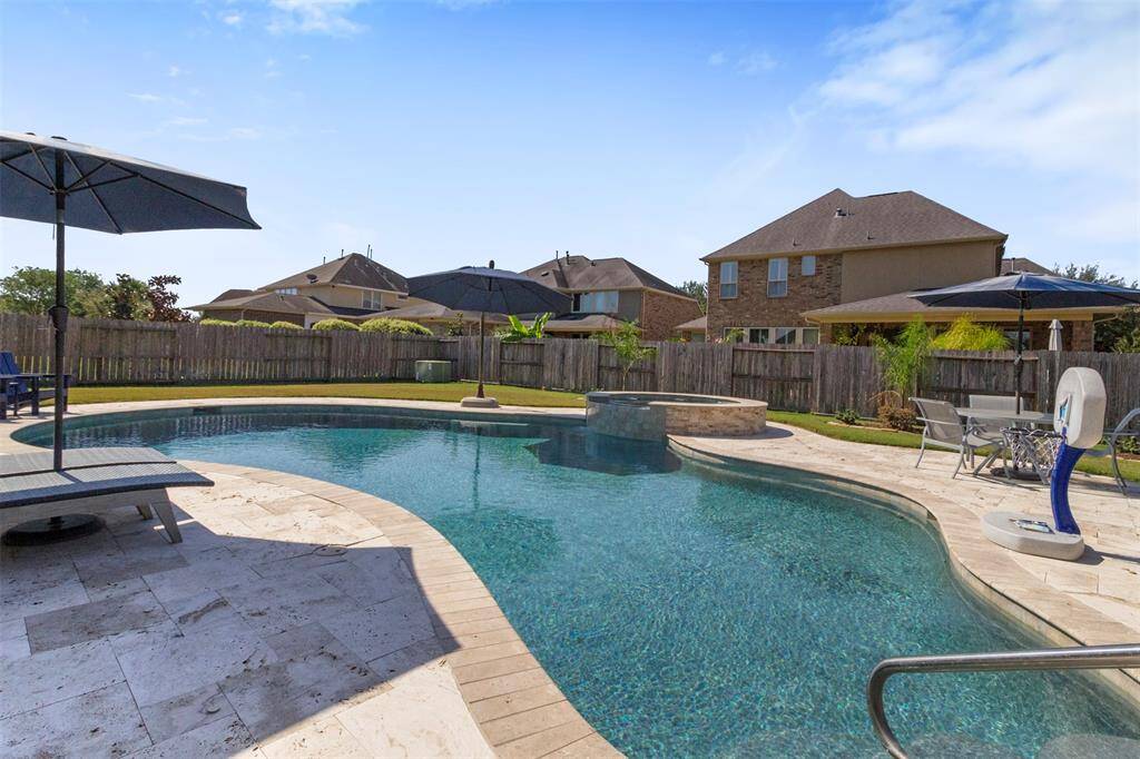 The paved walkway surrounds the pool and spa.