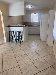 open kitchen/ breakfast room with Side by side refrigerator included with builtinn Bar with barstools