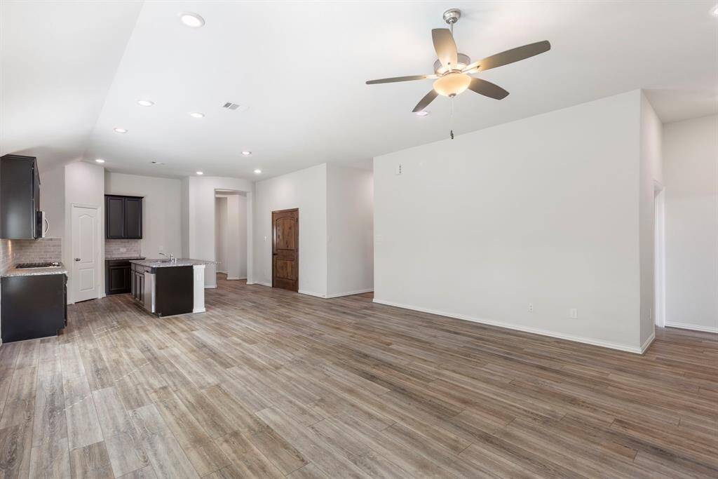 This open concept living space marries the island kitchen, dining area, and living room.