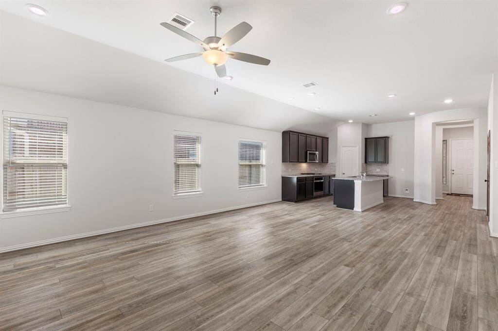 This open concept living space marries the island kitchen, dining area, and living room.