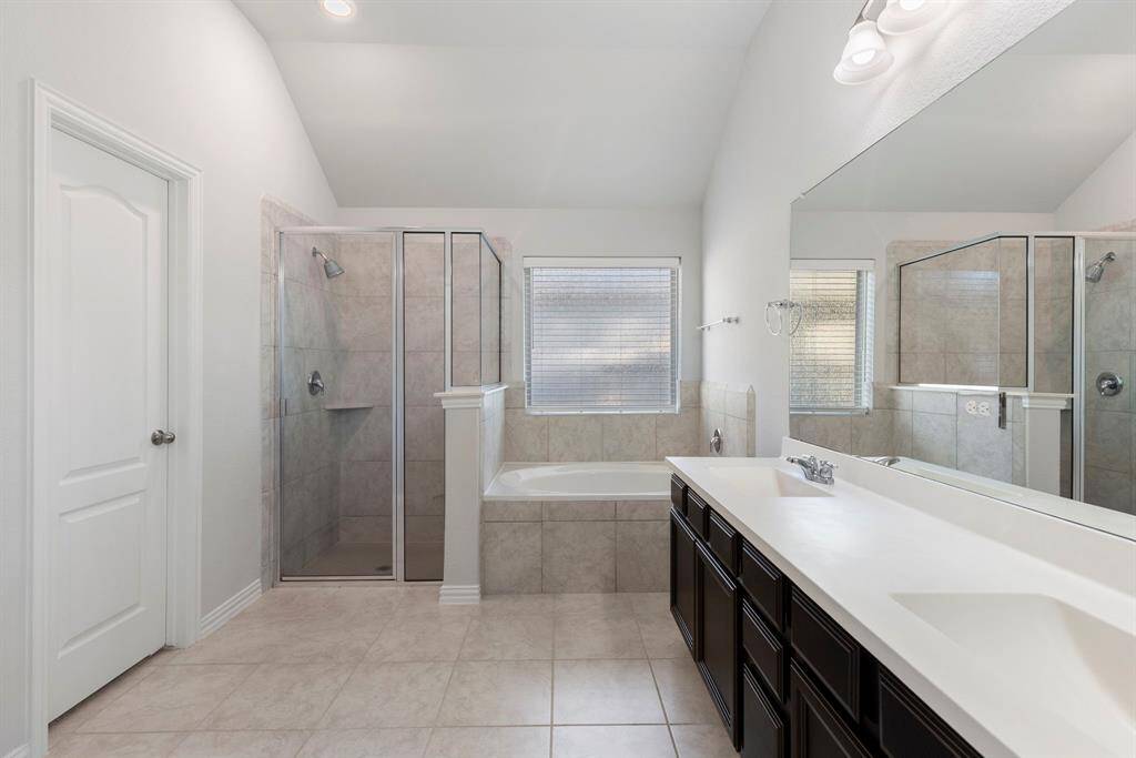 The primary bathroom features double sinks, large soaking tub, and separate shower.