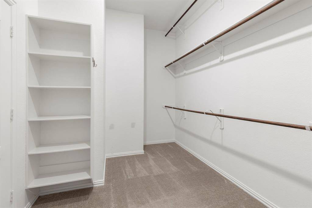 The large walk-in closet has custom shelving for storage and don't miss the 3rd rack for hanging items