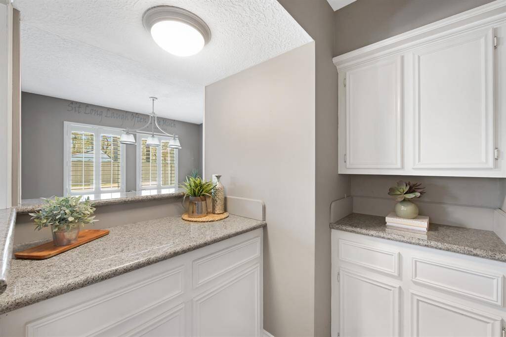 An added touch to the home is the elegant dry bar area, featuring sleek granite countertops and built-in cabinets for stylish storage. It’s a perfect space for entertaining, offering both functionality and a sophisticated flair.