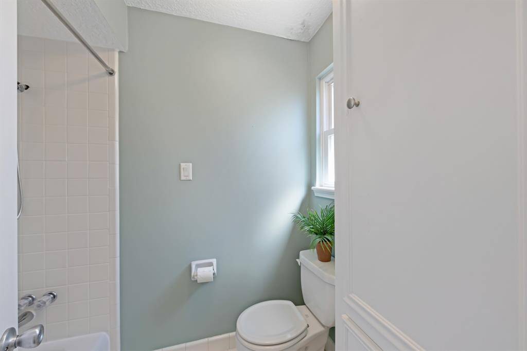 Tub/shower combo in the secondary bathroom with added cabinets for storage.