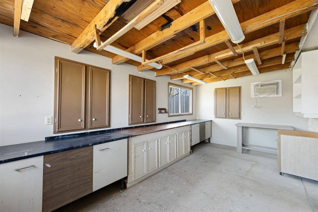 Attached to the back of the garage is an added workshop, complete with built-in shelves and cabinets, providing a practical and organized space for all your projects and storage needs. It’s the perfect addition for DIY enthusiasts or anyone needing extra workspace.