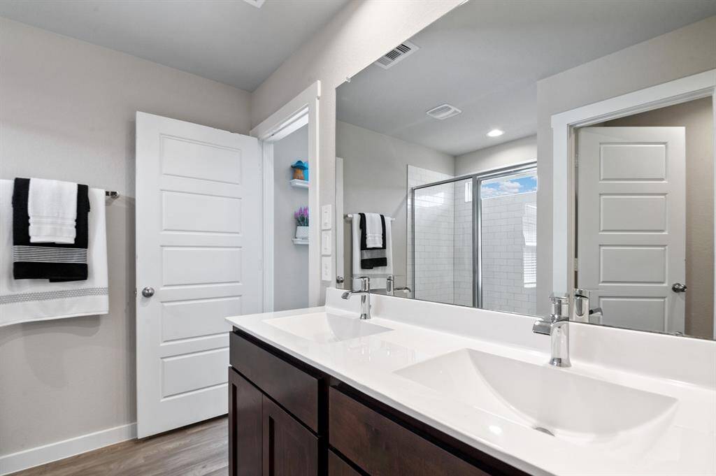 Primary bathroom features two sinks and an oversized walk-in shower with subway tiles.