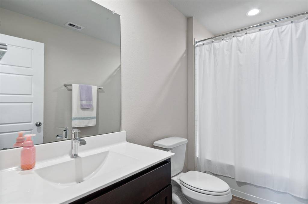 Secondary bathroom is well placed in between both of the secondary bedrooms.  It features chrome fixtures, subway tile and vinyl flooring.