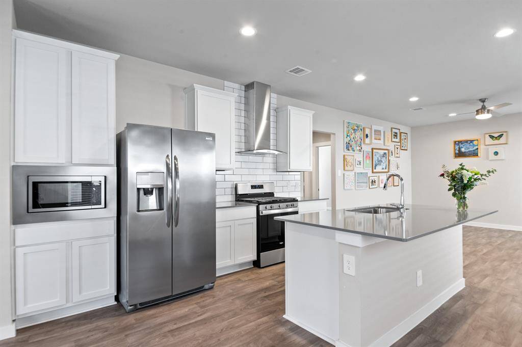 Kitchen features stainless steel appliances and a built-in microwave.