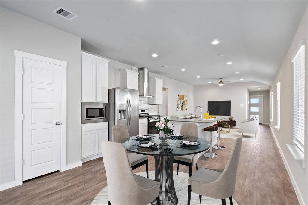 View of the open concept dining, kitchen and living spaces.  *Image is virtually staged.