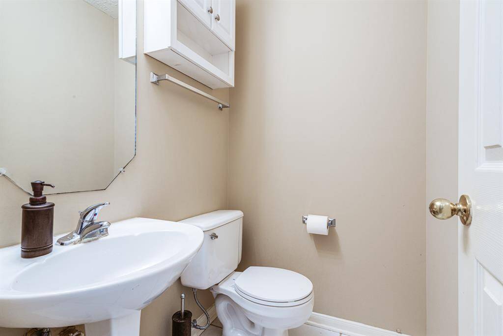 Half bathroom, located downstairs for convenience. The walls are painted in a neutral tone, providing a clean and simple look.