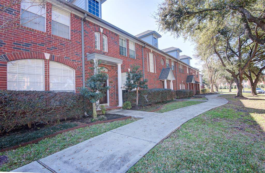 This townhome is surrounded by mature trees and landscaped shrubbery, offering a welcoming and serene environment.