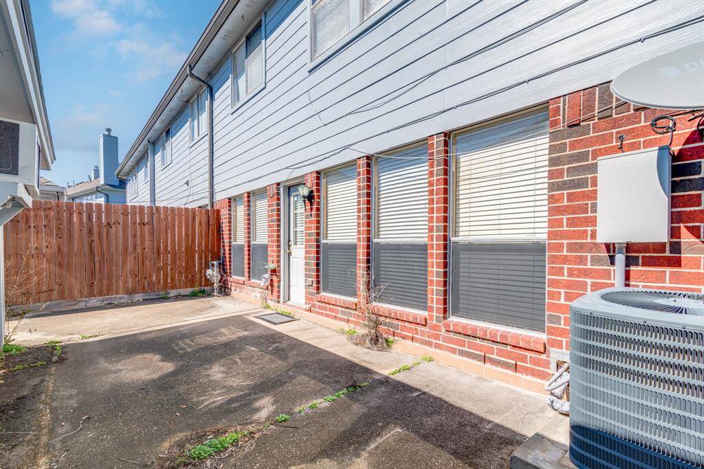 This is the paved backyard area with a brick exterior and siding! A wooden fence providing privacy! The space is compact, ideal for minimal maintenance.