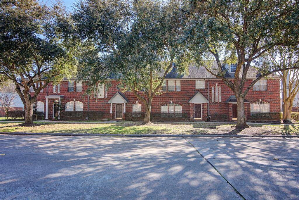 This townhome is surrounded by mature trees and landscaped shrubbery, offering a welcoming and serene environment.