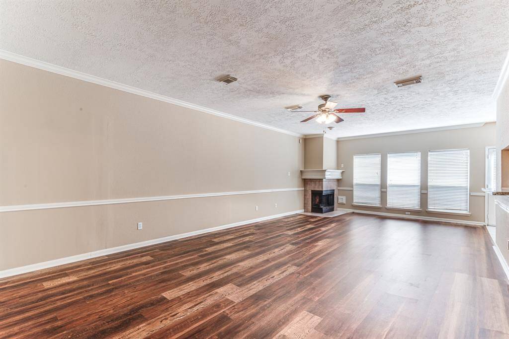 The neutral walls and ceiling fan add a welcoming touch, ideal for comfortable living and entertaining.