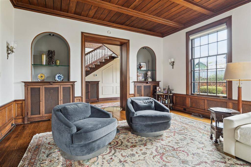 Showcasing exquisite craftsmanship, this welcoming space features rich wood paneling, arched niches, and custom built-ins that exude timeless elegance.