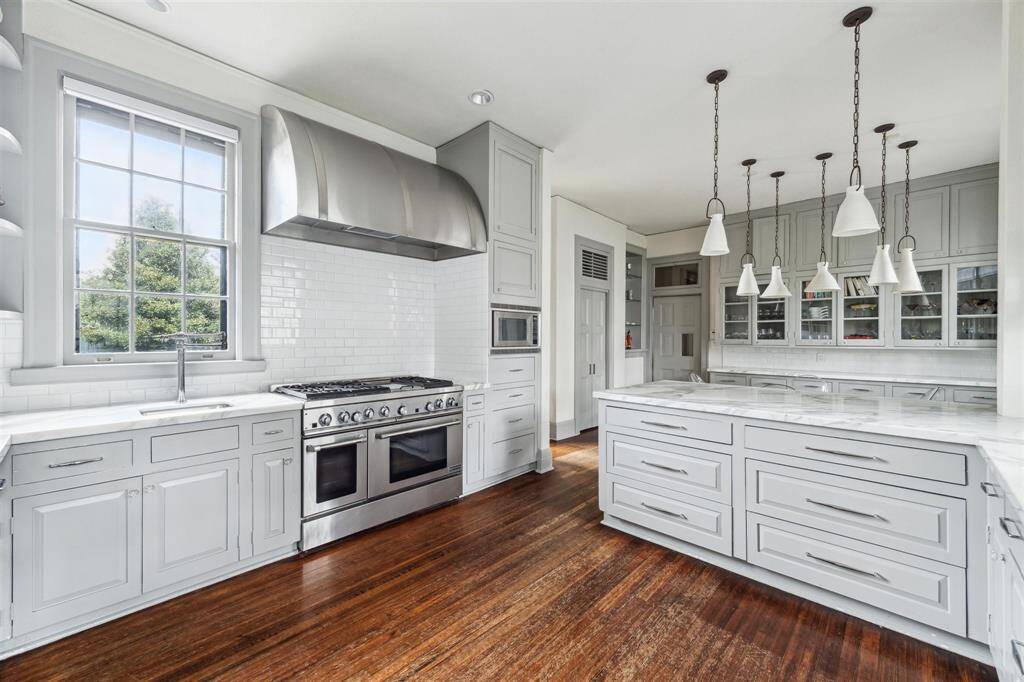 From this vantage point, notice the spacious kitchen featuring expansive marble counterspace and an additional sink for convenience, seamlessly connecting to the breakfast area, while a charming café door separates the mudroom.