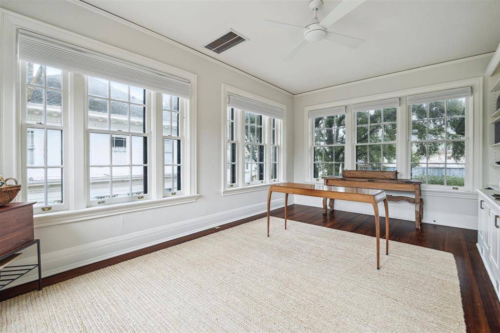 Located off the primary bedroom, this light-filled sitting room features expansive windows offering serene views and abundant natural light. With gleaming hardwood floors and a tranquil atmosphere, it’s the perfect space for relaxation, reading, or a private retreat.