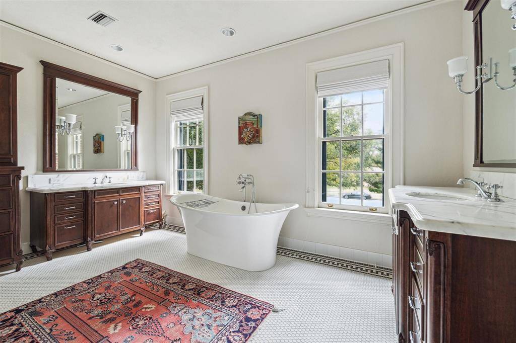 Truly, this primary bath is a serene retreat with peaceful views. Notice the tile flooring showcases the same elegant Greek key element seen throughout the home.
