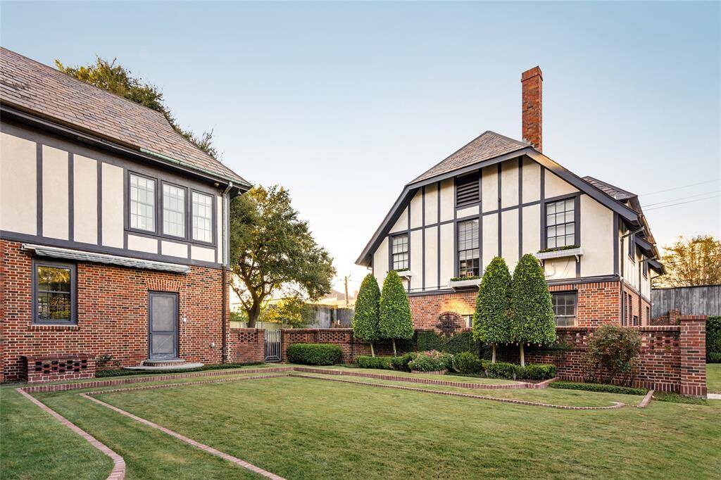 Step into this meticulous backyard, where classic Tudor-style architecture meets lush, manicured landscaping maintained by Lanson B Jones & Co. Brick pathways and elegant topiaries add structure and charm, creating a serene and private outdoor space perfect for entertaining or enjoying quiet moments of relaxation.