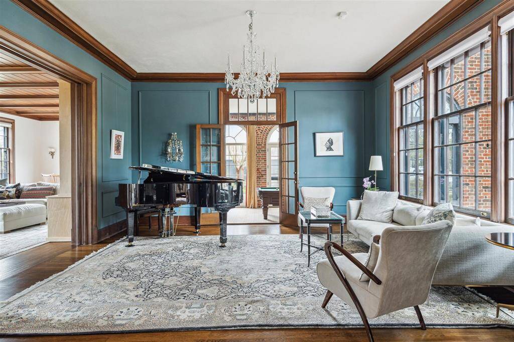 The beautifully designed living room with abundant natural light, featuring pocket doors to the family room and French doors to the sunroom, provides the flexibility to create a private space or maintain an open flow for daily living.