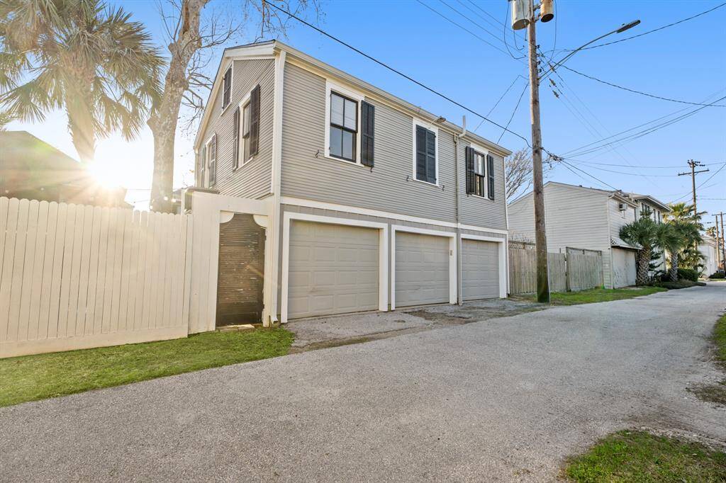 View of three car garage with apartment above from the dead end alley.