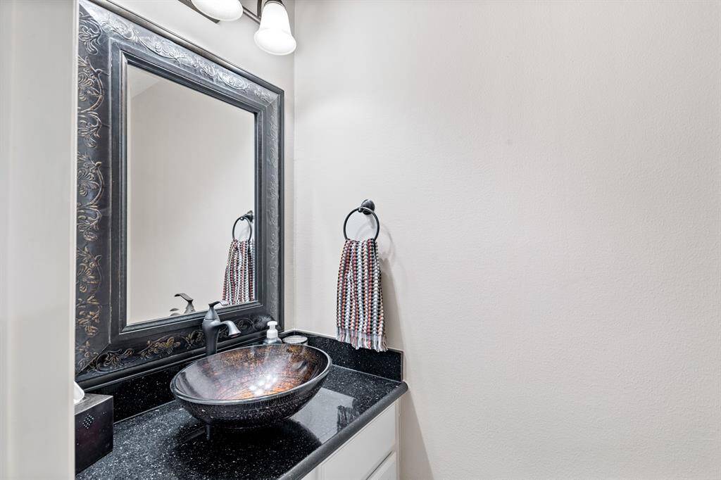 Powder room is tastefully renovated and conveniently located in the hallway connecting the dining room and the kitchen.