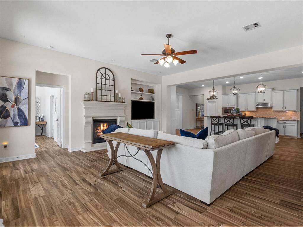 The living room’s design merges effortlessly with the kitchen, forming a unified living area. This space is tailored for both relaxation and gatherings.