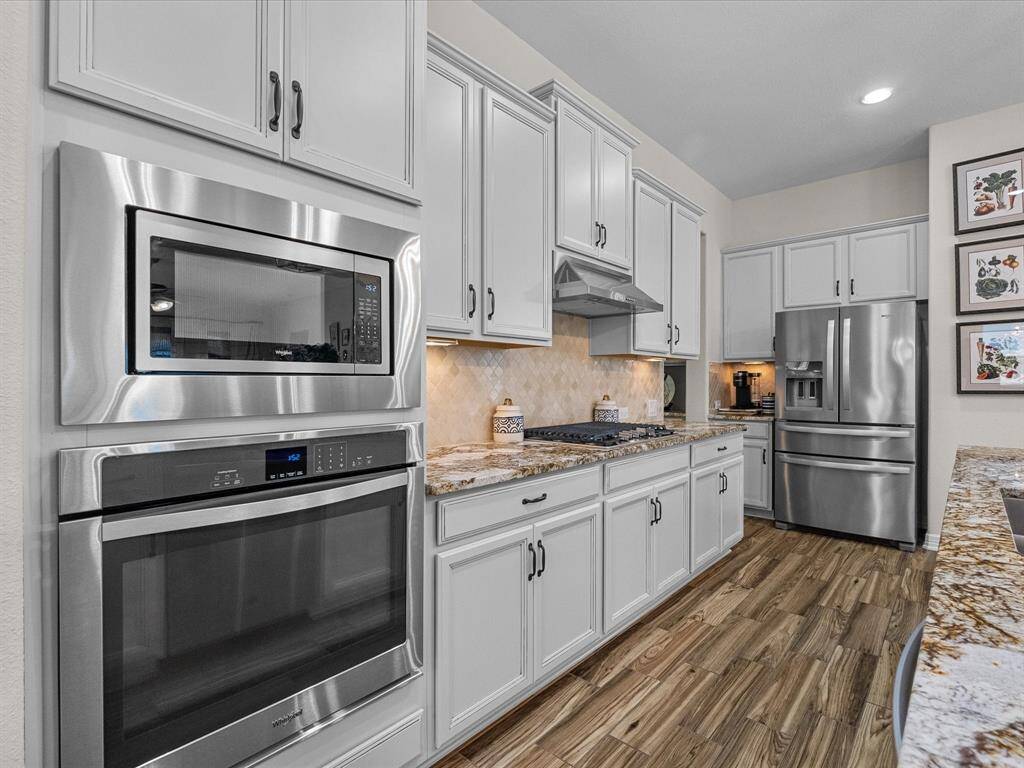 The kitchen features modern cabinetry, stainless steel appliances, and a granite countertop. The layout maximizes space and functionality.