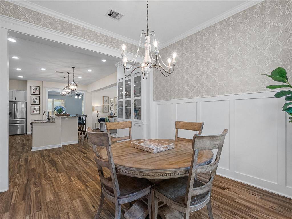 Crown molding and beautiful trim and modern light fixtures. The room flows seamlessly into the kitchen and living areas.