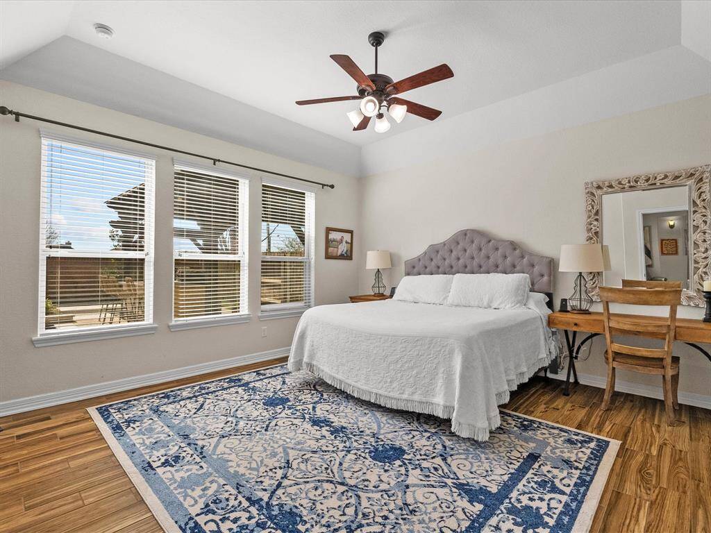 Primary bedroom features natural light and view of dream backyard. Spacious space offers a tranquil retreat.