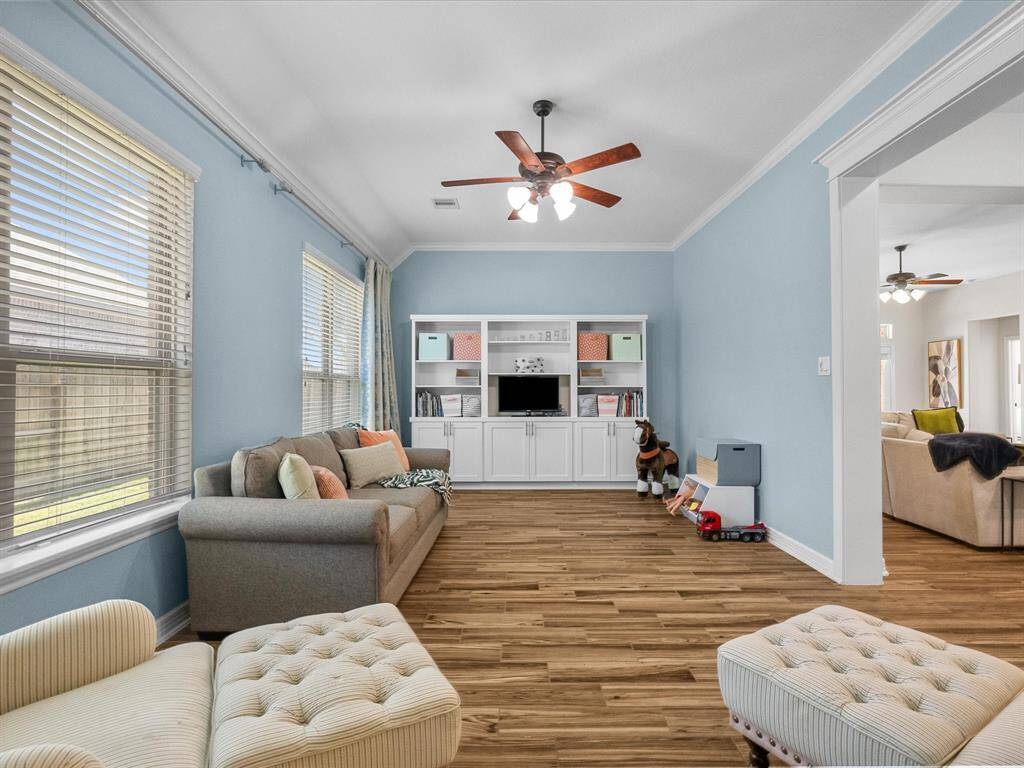 The playroom, game room, library, or just extra living space features built-in cabinets and shelving, offering ample storage and organization.