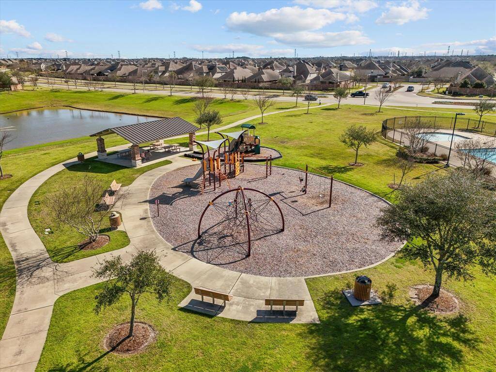The community playground, shaded picnic area, and walking paths. The park offers recreational space and green areas for residents to enjoy.