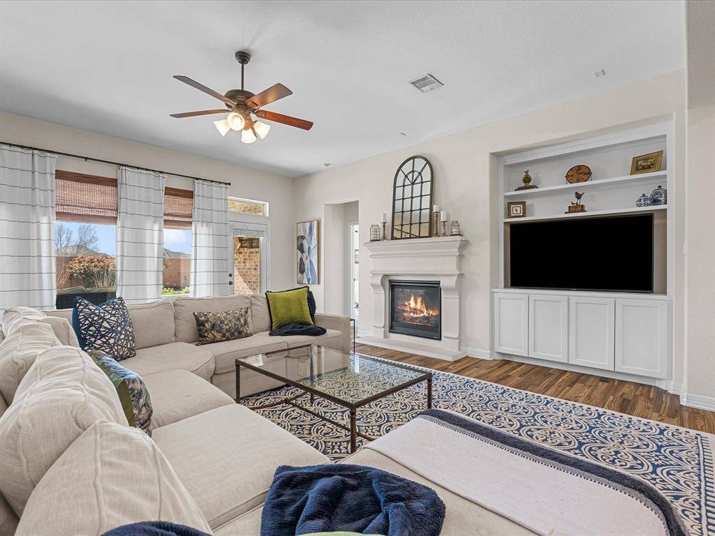 The living room boasts a fireplace and built-in shelving, providing both style and functionality. The open layout ensures a smooth transition to other areas of the home.