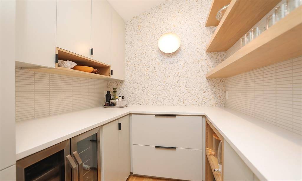 Custom butlers pantry includes a coffee bar (not pictured), wine fridge, and modern shelving.