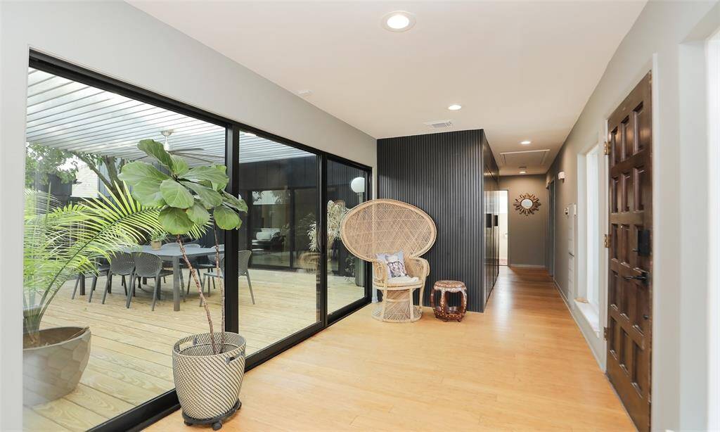 Entryway with natural bamboo floors and view to interior atrium, surrounded with 3 walls of sliding doors, perfect to bring the outdoors in!