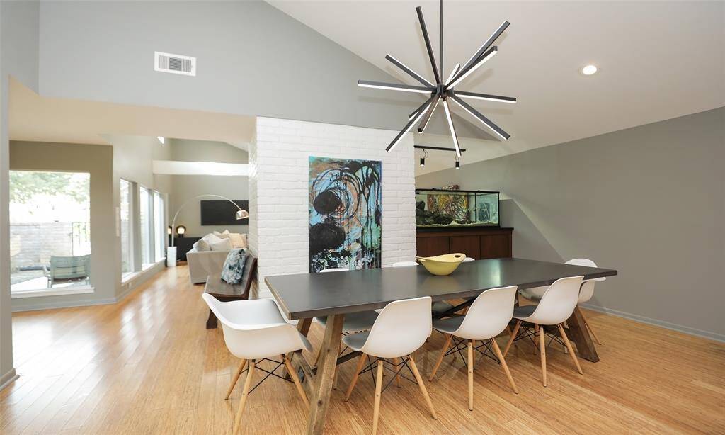 A view back at the white brick fireplace, entrance, living room and dining space.