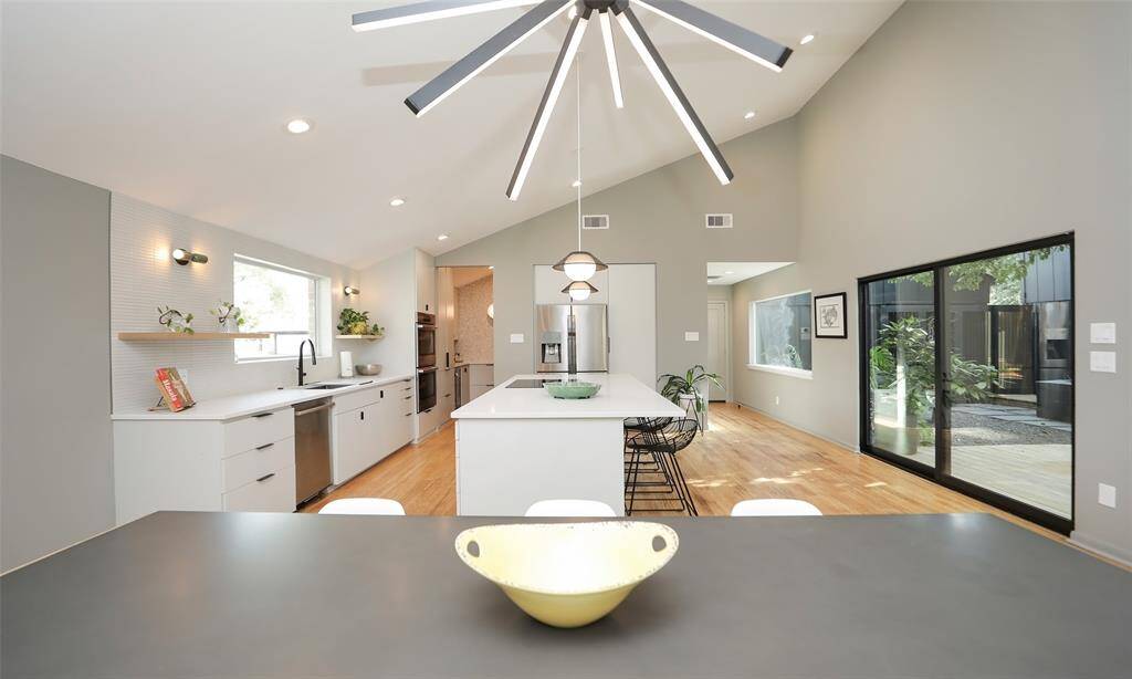Dining space is lit with a modern champagne gold lighting fixture to perfectly fit the modern structure.