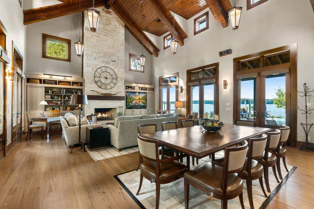 Casual yet so elegant! The stone floor to ceiling fireplace demands attention as well. Note the TV cabinet is open. It has 3 retractable cabinet doors to hide TV when not in use. Gleaming wood floors. Look at that view!