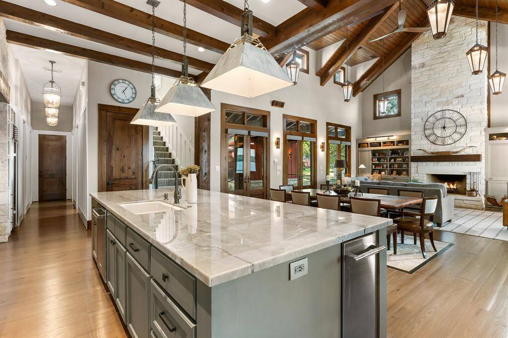 From this central hub, one accesses the hall to the 2nd huge walk-in pantry with 2nd fridge and the laundry room on the right and Guest half bath on the left with door at the end to the spacious garage. Also one sees the stairs up to 2 additional bedrooms and a large Flex/game room.