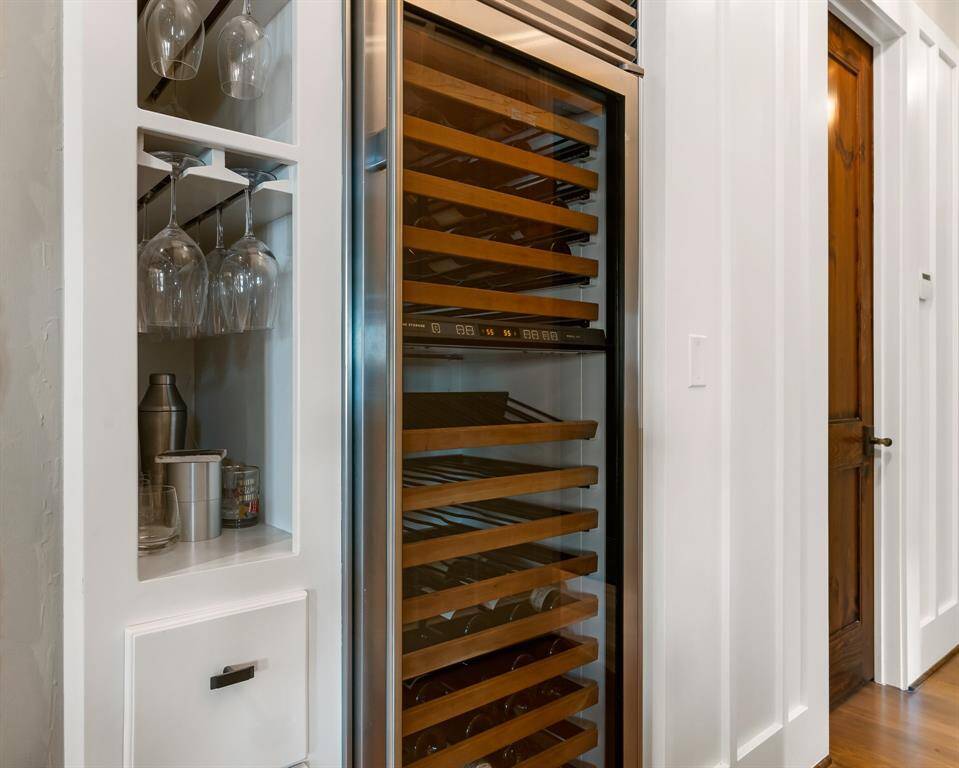 This temperature controlled beverage cooler and storage is adjacent to the kitchen in the hall. The closed door is a Guest half bath.