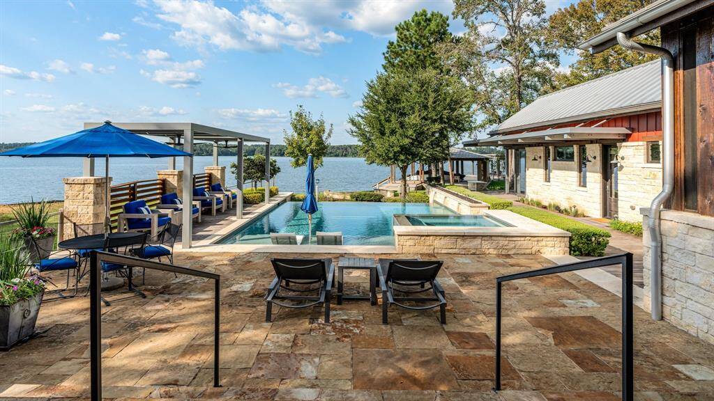 Such a pretty "resort like" setting. Sizeable vanishing edge pool is surrounded by convenient luxury like no other to ensure privacy in this area. The inclusive "Pool House" will become a favorite place to stay when visiting this property! There is a huge firepit lakeside just beyond the pool with built-in stone seating surrounding. Not seen here is the expansive covered porch overlooking all.